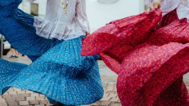 women wearing traditional outfits dancing on a street